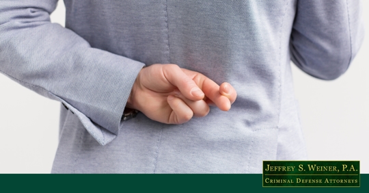 person with fingers crossed behind their back